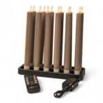 Een set van zes oplaadbare 97 mm warmwitte LED dinerkaarsen (130 uur per stuk) met afstandsbediening staat op een zwarte voet, samen met een plug-in voedingsadapter.