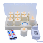 De set "LED-Teelichter wiederaufladbar mit beweglicher Flamme (12 Stück) warmweiß mit Fernbedienung" bevat zwölf LED-Teelichter in weißen Haltern, Ladestation, Fernbedienung en weißes Netzteil mit EU-Stecker.
