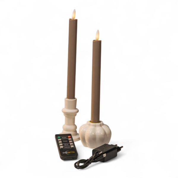 Home 15 Twee bruine vlamloze LED conische kaarsen in witte houders, afgebeeld met een zwarte afstandsbediening en een zwarte voedingsadapter, alles geplaatst op een witte achtergrond.