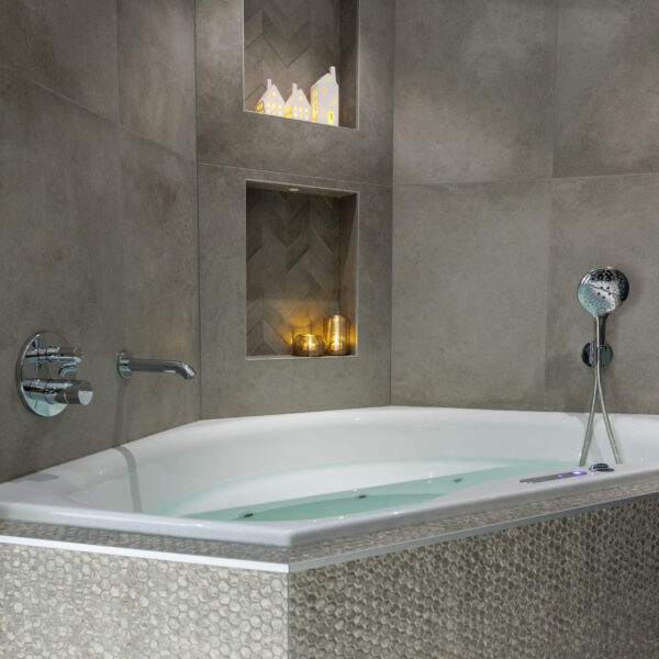 Eine moderne Badewanne mit Mosaikfliesen verfügt über eingebaute Regale, die LED-Teelichter wiederaufladbar mit Fernbedienung, wasserdicht und bis zu 400 Stunden Brenndauer, sowie Keramikhäuser aufnehmen und eine gemütliche und entspannende Atmosphäre schaffen.