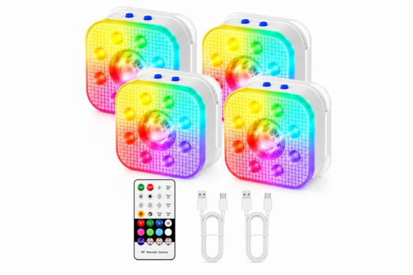 Vier vierkante LED puck lampen geven regenboogkleuren weer, elk met een koepel in het midden en knoppen aan de zijkant. Een RF-afstandsbediening en twee USB-oplaadkabels zijn onder de lampjes geplaatst op een witte achtergrond.