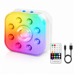 Vierkant LED-lichtpaneel met een gestructureerd oppervlak dat oplicht in regenboogkleuren, acht ronde lampjes rondom een centraal lampje en blauwe knoppen bovenop. Inclusief afstandsbediening en USB-oplaadkabel.